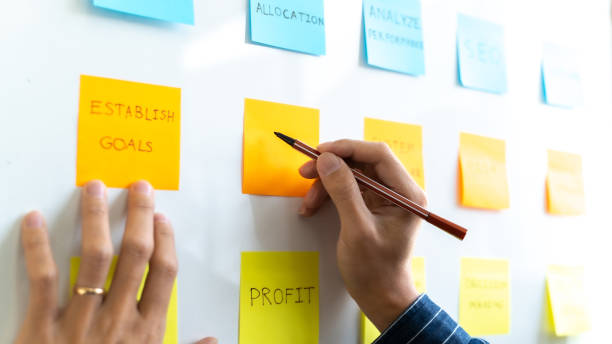 istock Team working in office putting sticky note on white board analyzing strategy of business. 1268237362