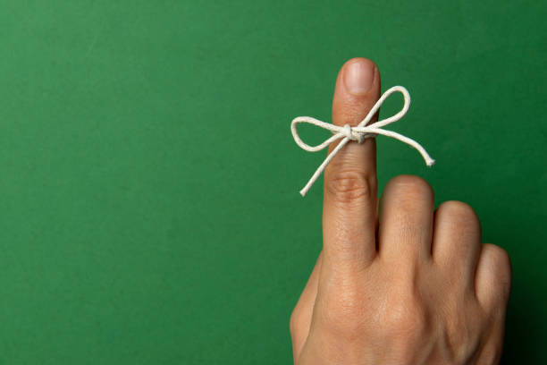 hand and string tied on index finger - reminder memories human finger string imagens e fotografias de stock