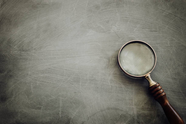 istock vintage magnifying glass with wooden handle over chalkboard background. top view, flat lay 1268240845