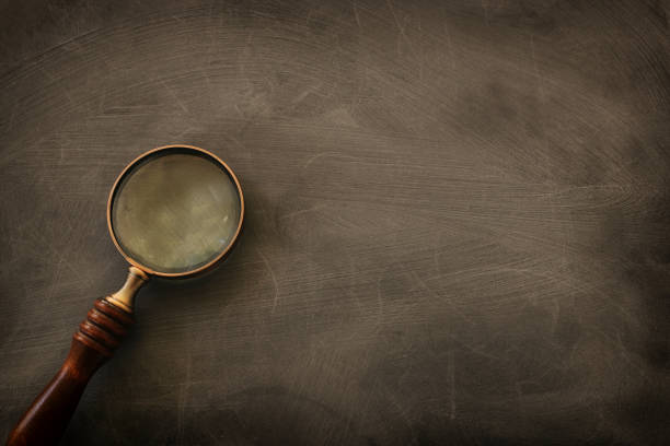 istock vintage magnifying glass with wooden handle over chalkboard background. top view, flat lay 1268240859
