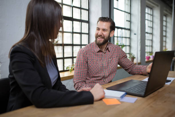 istock Two young coworkers talking about business innovations 1268242001