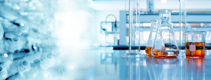 Close-up View Of Laboratory Glasswares And Tubes With Different Liquids For Scientific Research And Experiments. Modern Laboratory With Blurred Background