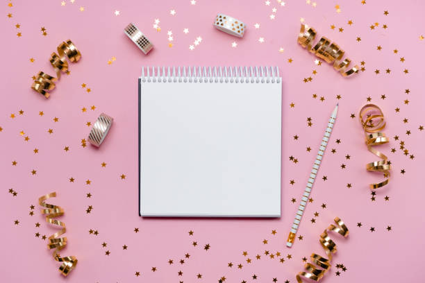 istock New Year decorations and blank white spiral notebook on pink background. Planning, wish list and resolution 2021 concept. 1268243015