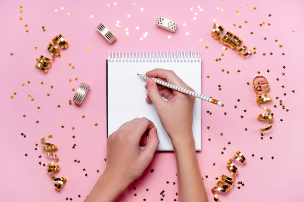 istock New Year decorations and blank white spiral notebook on pink background. Planning, wish list and resolution 2021 concept. 1268243018