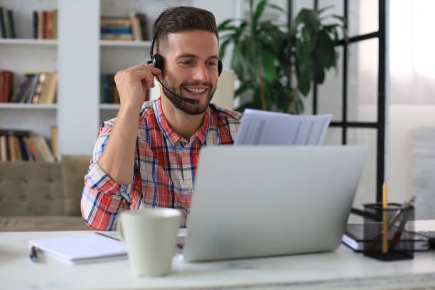 istock Concentrated young freelancer businessman using laptop for video conferance, working remotely online at home. 1268243159