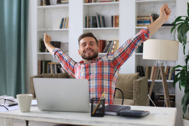istock Smiling handsome businessman relaxing at home office. 1268244500