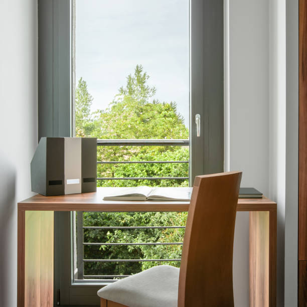 istock Simple wooden desk by window 1268244624