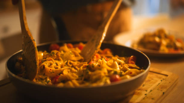 person serving delicious looking pasta on the plate. serving profesionally cooked pasta dish in the restaurant or for romantic dinner meal at home. close-up shot - gourmet enjoyment food freshness imagens e fotografias de stock