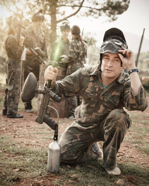 istock Man wearing uniform and holding gun ready for playing with frien 1268244983