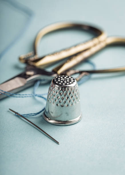 vintage silver thimble on blue - thimble sewing item close up studio shot imagens e fotografias de stock