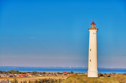 Beautiful sunset at the white lighthouse Lyngvid near Hive Sande in Denmark.