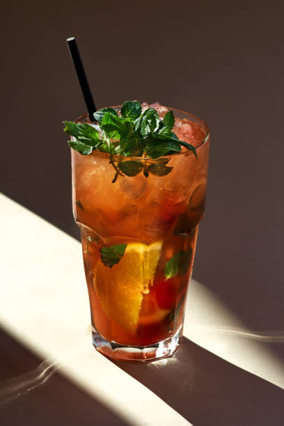 istock Red mojito cocktail with ice, mint leaves on paper background in selective focus, sunlight 1268252126