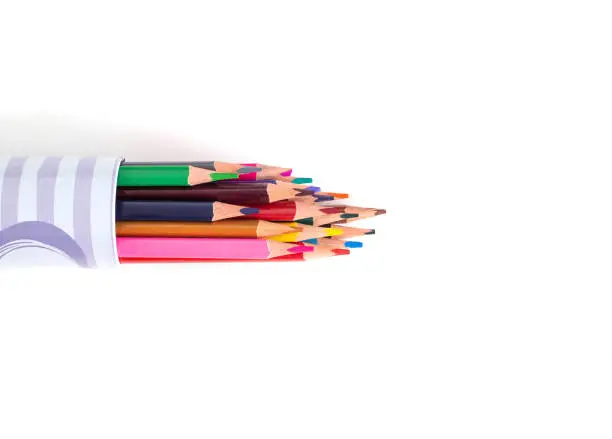 Multi-colored pencils in a tube on a white background. School supplies and stationery concept, pencil-case