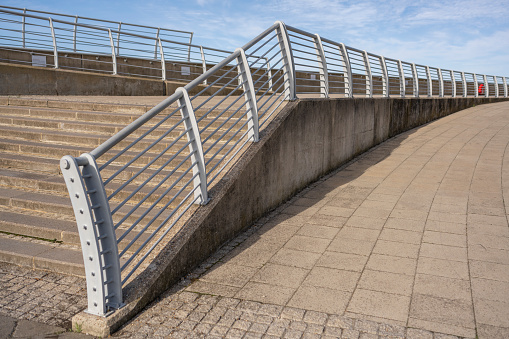 Concrete stairs and metal railing on the banks of the River Thames in South East London, around Woolwich Arsenal.