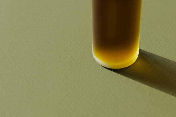 Hemp oil bottle with long shadow on textured green paper. Hemp oil bottle with long shadow on textured green paper. Poster, banner with copy space. Natural herbal cosmetic, aromatherapy. Grassy olive colors. Frosted vial with organic extract, emulsion, serum harsh shadows stock pictures, royalty-free photos & images