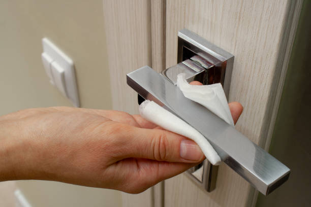 istock Hand rubs door handle with an antibacterial wipe 1268260985