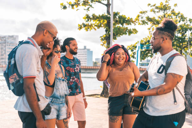 istock Friends playing guitar and singing outdoors 1268261008