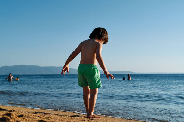 istock Cute child on beach at sunny day 1268261675