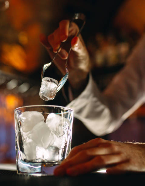 istock The bartender pours ice into cocktail glasses. 1268261718