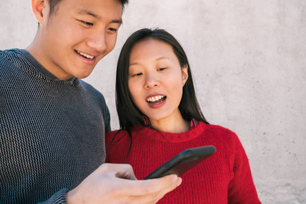 istock Asian couple looking at the mobile phone. 1268261808