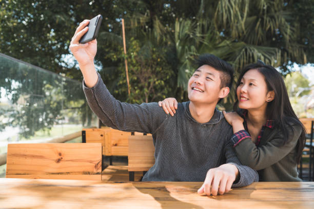 istock Asian couple taking a selfie with mobile phone. 1268261811