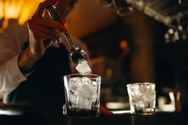 istock The bartender pours ice into cocktail glasses. 1268262058