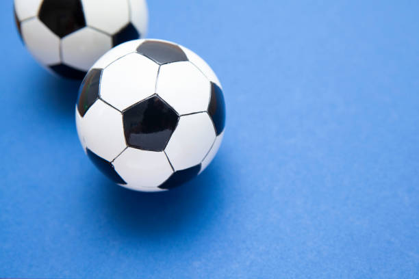 istock Mini soccer balls on a blue surface with copy space 1268262204