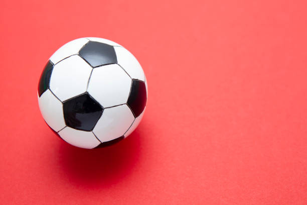 istock Mini soccer balls on a red surface with copy space 1268262435