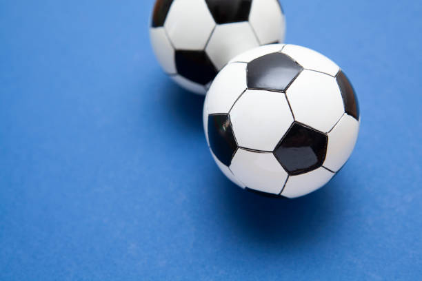 istock Mini soccer balls on a blue surface with copy space 1268263213