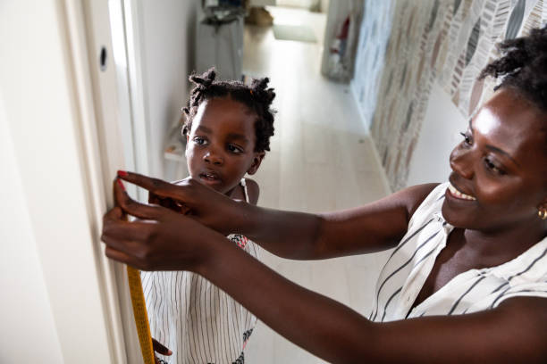 istock Mother checking daughters height at home 1268264845