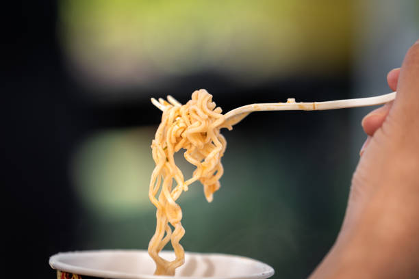 istock Eating instant noodles, cheap meal - People action. 1268266063