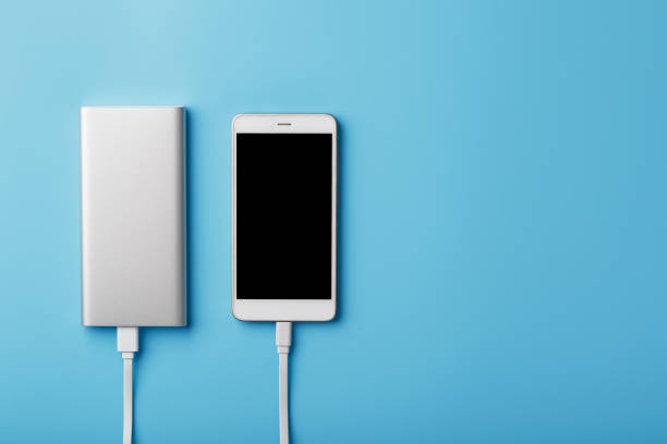 istock A charging phone with powerbank on blue background. Keep the battery charged on your device anyway you go. 1268268762