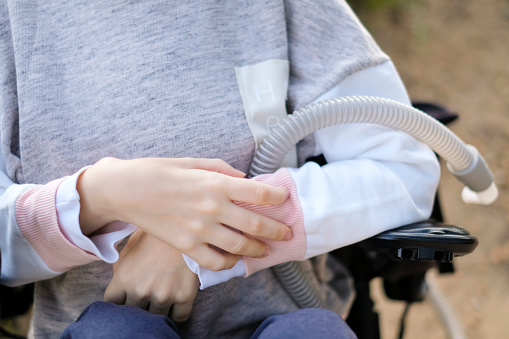 Manos de una persona discapacitada con distrofia muscular sosteniendo un respirador para respiración profunda, concepto, antecedentes photo