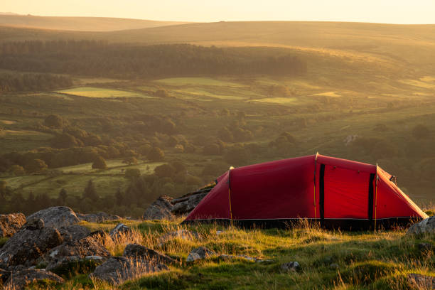 impresionante imagen de camping salvaje en el campo inglés durante el impresionante amanecer de verano con cálido resplandor del sol iluminando el paisaje - dartmoor fotografías e imágenes de stock