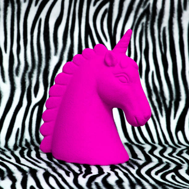 istock Pink unicorn souvenir on zebra print background Minimal art 1268272880