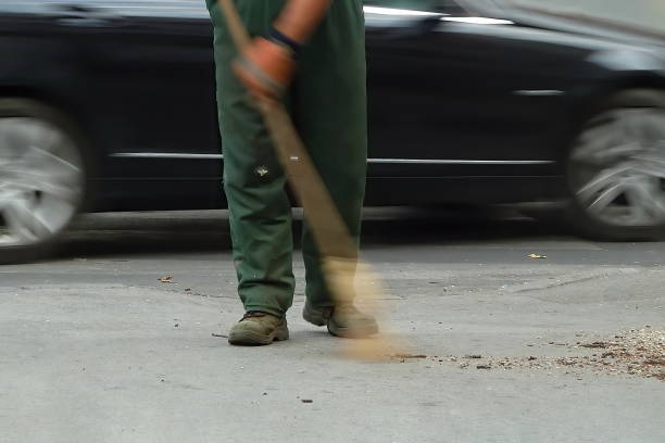 Street sweeper cleaning the sidewalk with a broom