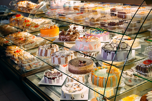 Pastry shop glass display with selection of cream or fruit cake