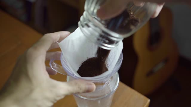 Pour ground coffee beans into a coffee dripper