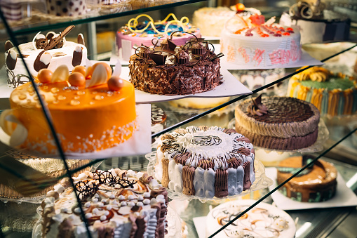 Pastry shop glass display with selection of cream or fruit cake