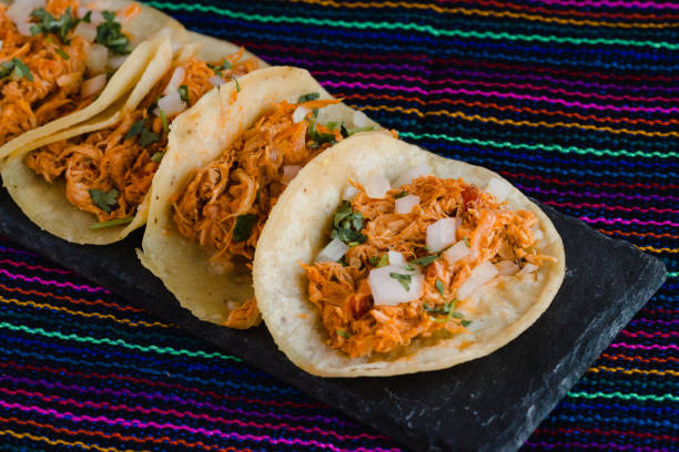 istock Mexican tacos filled with tinga de pollo on a traditional textile background 1268275498
