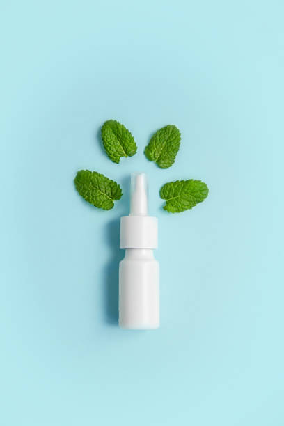 istock Nasal spray bottle and mint leaves on a blue background 1268278961