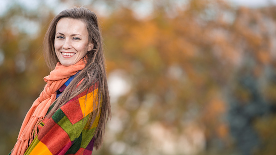 Autumn woman  wearing warm woolen clothes in bright colors walking in autumn park