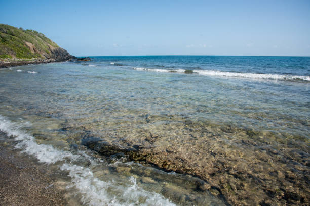 Flowing Caribbean Sea waters at remote beach with rocky fringe reef on St. Croix in the US Virgin Islands