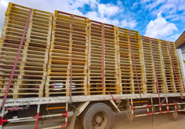 istock Worker driving forklift to loading and unloading wooden pallets from truck to warehouse cargo storage, shipment in freight logistics and transportation industrial, wood pallets stack 1268284937