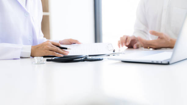 istock Medical doctor taking notes with patient in clinic. 1268285030