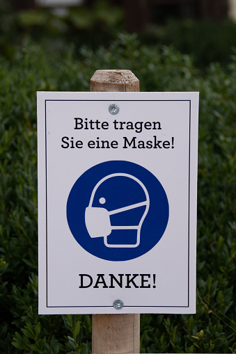 A mouth nose protection sign in a park.