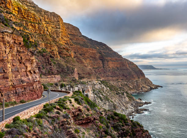 Highway road and mountains with foggy landscape at sunset This image shows beautiful coastal road in capetown. this shows curvy Highway road and cliff landscape . chapmans peak drive stock pictures, royalty-free photos & images