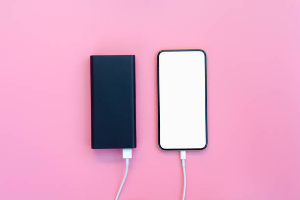 istock Smartphone charging with power bank on pink background. white screen or blank screen with clipping path for copy space. Flat lay 1268290318