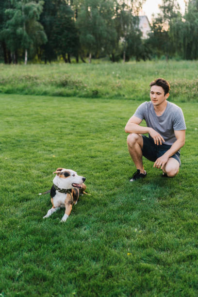 istock Man sitting with the  dog on lawn 1268290615