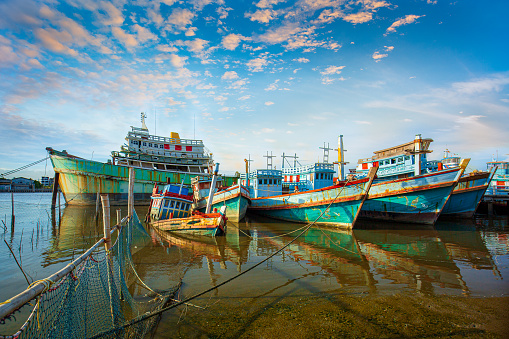 Many boats moored in sunrise morning time at Chalong port, Main port for travel ship to krabi and phi phi island, Phuket, Thailand